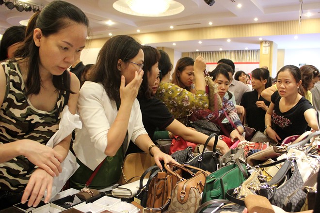 Ngay từ lúc mở cửa nhiều thương hiệu túi xách, giầy dép đã tập trung đông đảo khách hàng. Chị Nguyễn Thị Vân Anh (quận 5) cho biết muốn mua được món đồ ưng ý phải có mặt từ sớm, khách đông nên nhiều lúc phải tranh nhau lựa mới mua được.