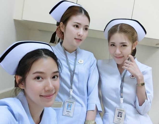 Maypimm chụp hình cùng các bạn trong trang phục y tá.