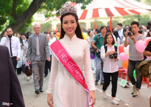 Tân Hoa hậu xuất hiện đơn giản trong chiếc áo dài nữ sinh trắng, đội vương miện hoa hậu và đi bộ từ ngoài cổng trường