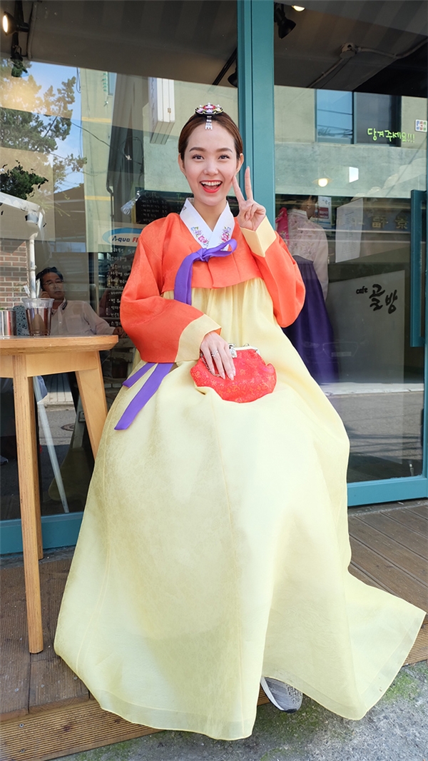 Trong chuyến tham quan, Minh Hằng diện hanbok truyền thống với hai sắc màu cam, vàng làm chủ đạo. Tuy nhiên, nữ ca sĩ lại mang giày thể thao năng động, trẻ trung trông khá lạ mắt.