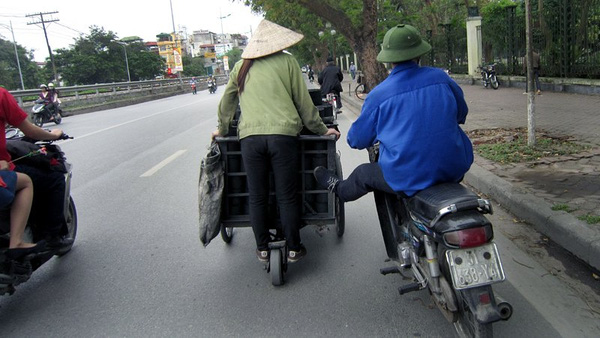 Dùng sức người đẩy xe chở than tổ ong được "cơ giới hóa" bằng xe máy trên phố Lê Duẩn