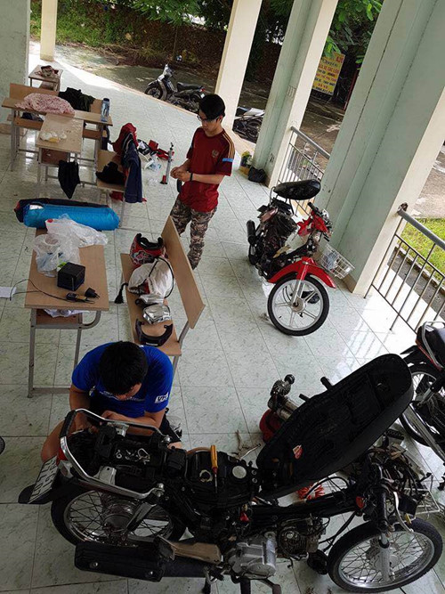 Bạn Nhật Minh (áo đỏ) và bạn Minh Hiệp (áo xanh) đang sửa chữa xe cho các sinh viên