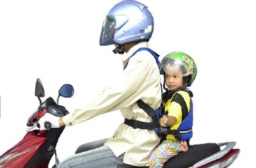 Vị trí an toàn hơn cả là cho trẻ ngồi sau lưng người lái và có địu/dây đai chằng chắc chắn nối bé với người lái. 