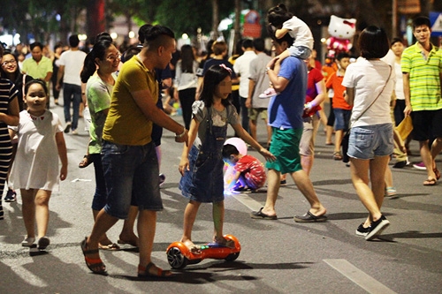 Khá đông trẻ em chơi xe điện cân bằng ở khu vực phố đi bộ Hồ Gươm