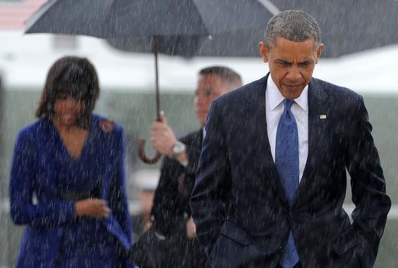 Tổng thống Mỹ Barack Obama để đầu trần bước đi giữa cơn mưa. (Nguồn: Getty Images)