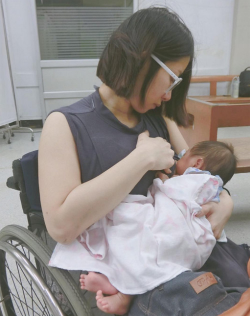 Bà mẹ trẻ người Thái Lan dù bị khiếm khuyết 2 chân vẫn cho con bú bình thường.