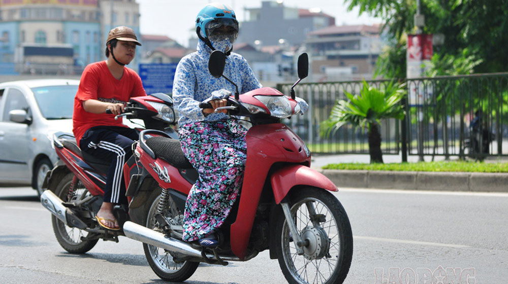 Khi đi xe máy, mẹ nên trang bị áo chống nắng, khẩu trang, kính râm để hạn chế tác động của nắng nóng, khói bụi.