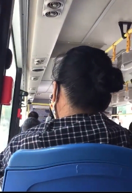 Người phụ nữ mặc áo kẻ chửi tục và tát một cụ bà lớn tuổi trên xe bus. (Ảnh cắt từ clip)