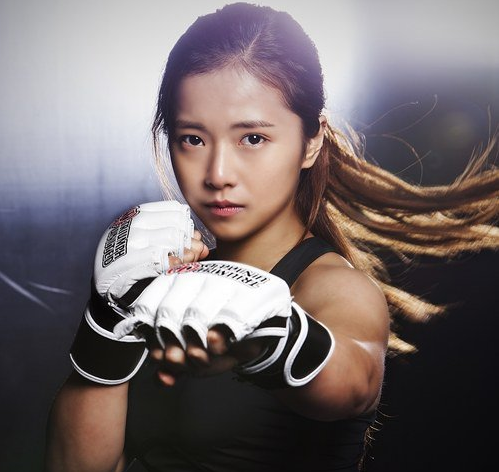Song Ga Yeon- sinh ngày 28/12/1994 là vận động viên thể thao chuyên nghiệp môn võ tổng hợp (MMA – Mixed Martial Arts) nổi tiếng tại Hàn Quốc. Cô nàng gây choáng ngợp bởi sở hữu một dáng vẻ rất nữ tính nhưng lại đi theo nghề đánh đấm thô bạo, dễ tổn thương thân thể.