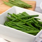 boiled green beans in a white square bowl
